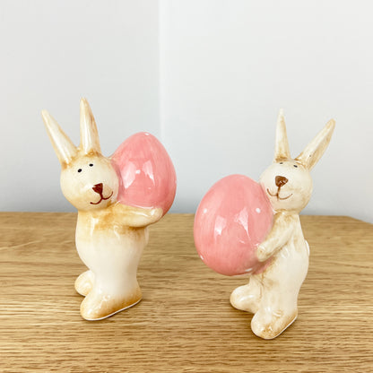 Pair of Cute Easter Bunnies Holding Eggs