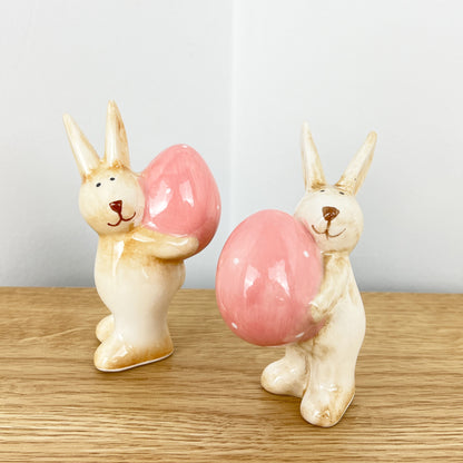 Pair of Cute Easter Bunnies Holding Eggs