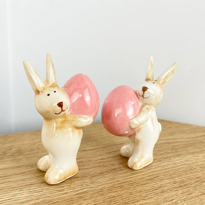 Pair of Cute Easter Bunnies Holding Eggs