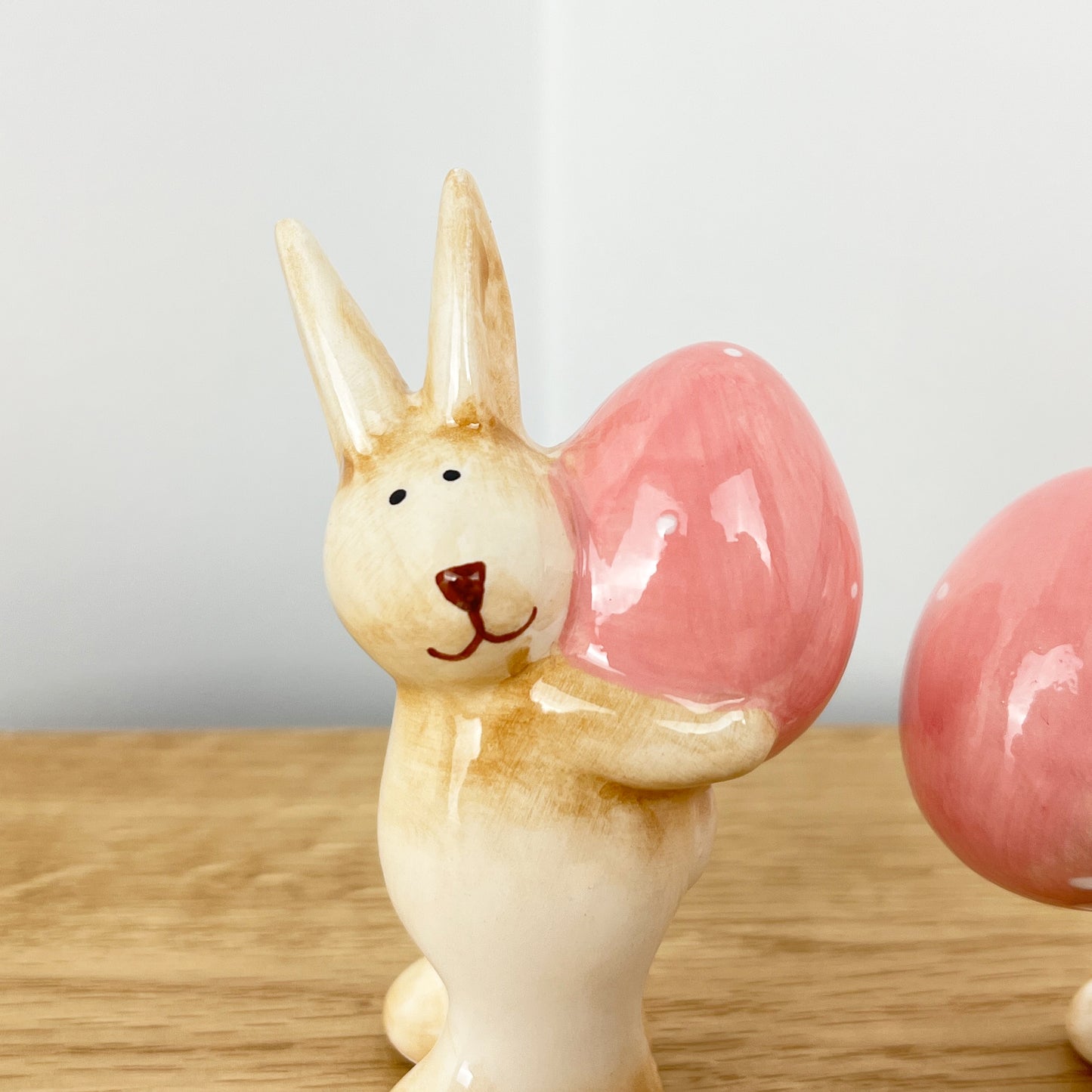 Pair of Cute Easter Bunnies Holding Eggs